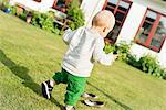 Baby boy walking in garden