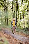 Beautiful blonde woman walking on road surrounded by forest