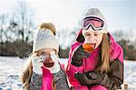 Mother and daughter drinking tea on a beautiful snowy day