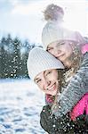 Piggyback with mother and daughter on a beautiful snowy day