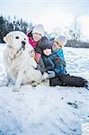 Family posing with a dog on a beautiful snowy day