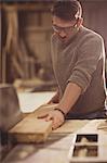 Carpenter working on his craft in a dusty workshop