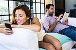 Couple using wireless devices at home