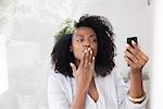 Woman blowing kiss at smartphone while doing video chat