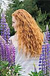 Rear view portrait  of young woman with long red hair  amongst purple wildflowers