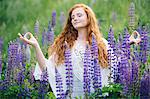 Serene young woman meditating amongst purple wildflowers