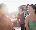 Group of young people, men and women walking on the open road with a boombox.