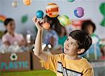 A boy looking up at a display of the planets, a presentation of the planetary system.