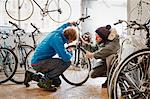 Two young men in a cycle shop, talking.