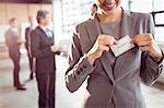 Businesswoman putting on name badge at the office