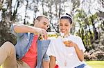 Smiling couple drinking wine on picnic blanket in the garden