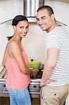 Smiling couple preparing vegetables in the kitchen at home