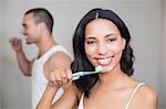 Couple brushing teeth in front of mirror in bathroom