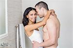 Smiling couple in underwear hugging in bathroom