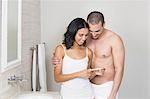 Smiling couple looking at pregnancy test in bathroom
