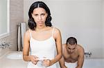 Frustrated couple having a positive pregnancy test in bathroom