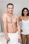 Smiling couple looking at mirror in bathroom