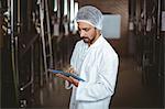 Happy brewer working in the plant with tablet at the local brewery