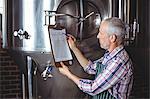 Happy brewer checking his list at the local brewery