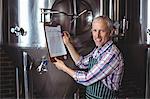 Happy brewer checking his list at the local brewery