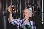 Happy brewer working in the plant at the local brewery