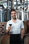 Smiling vintner with red wine at the