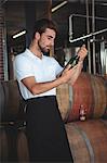 Handsome brewer checking at a wine bottle in a brewery