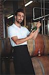 Handsome brewer checking at a wine bottle in a brewery