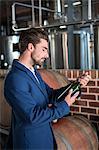 Well dressed man examining bottle of wine at winefarm