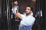 Focused brewer testing his beer in the brewery factory