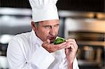 Chef smelling fresh basil in a commercial kitchen