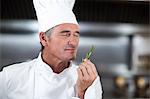 Chef holding fresh rosemary sprig in a commercial kitchen