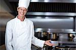 Happy chef smiling at camera in a commercial kitchen