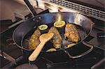 Fish frying in a pan in a commercial kitchen
