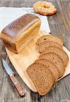 bread on a cutting board and knife beside