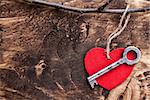 Love concept. An Old key and a heart on wooden background