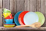 Kitchen utensils on shelf against rustic wooden wall