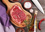 Raw beef steak and spices on wooden table. Top view