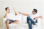 Men arguing. Two young male friend having argument at home. Multiracial people friendship.