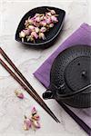 Asian rose tea and teapot over stone table