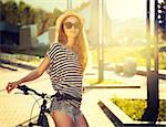 Trendy Hipster Girl with Bike on Urban Background. Toned and Filtered Photo. Modern Youth Lifestyle Concept.