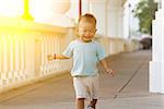 Portrait of young kid running and smiling outdoor in sunset.