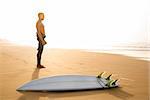 A surfer with his surfboard at the beach