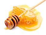 Honey dipper with honeycomb close up on white