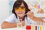 Young pupil conducting a simple chemical experiment in elementary science class