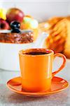 Colorful orange cup of  black tea on sunlight morning kitchen