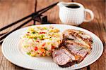 Asian style food - fried duck breast and jasmine rice with vegetables and eggs