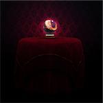 Fantasy magic crystal ball on the table with red cloth