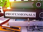 Professionals - Black Office Folder on Background of Working Table with Stationery and Laptop. Professionals Business Concept on Blurred Background. Professionals Toned Image. 3D.