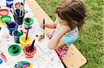 5 year old girl painting at a table in the garden, Sweden